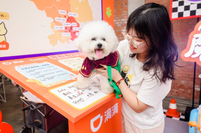 图为：滴滴体验监督员带小狗卢布“签署”宠物友好公约